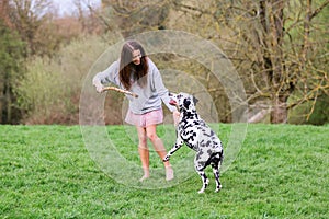 Young woman plays with Dalmatian dog outdoors