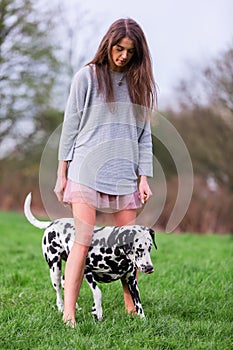 Young woman plays with Dalmatian dog outdoors