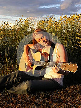 A young woman plays a guitar