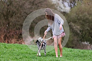 Young woman plays with her Dalmatian dog