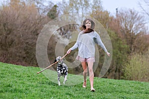 Young woman plays with her Dalmatian dog