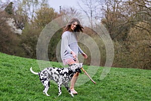 Young woman plays with her Dalmatian dog