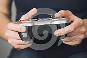 Young woman plays video game using a gamepad