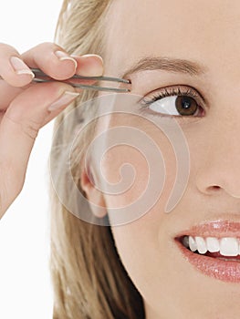 Young Woman plucking Eyebrow