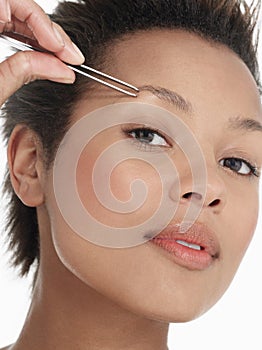 Young Woman plucking Eyebrow