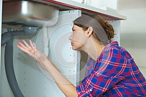 Young woman with plumber problem in kitchen