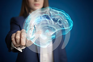 Young woman pointing at digital image of brain on background, closeup