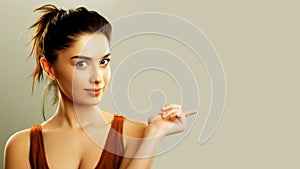 Young woman pointing finger to copy space