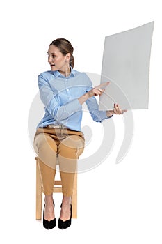 Young woman pointing fingr and presenting on empty board