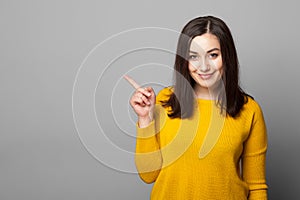 Young woman pointing to blank space