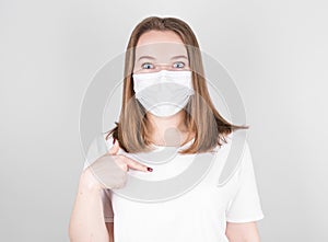 Young woman points her finger at herself. Shows the importance of wearing a mask for prevention of coronavirus infection and colds