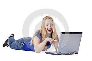 Young woman points surprised to computer monitor