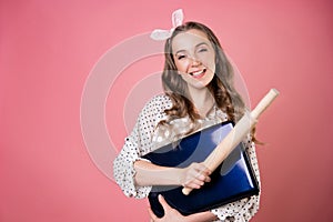 young woman in a polka dot apron is looking for a recipe for a dish on the Internet, learning how to cook.