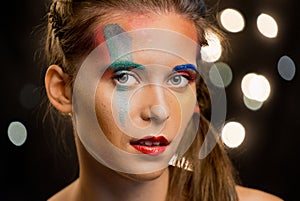 Young woman portrait, multicolor face painting. Model with make up. Girl with art paint