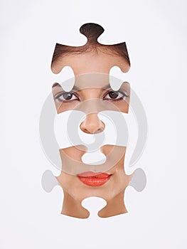 Young woman, portrait and puzzle for makeup, cosmetics and dermatology transformation on a white background. Face of a