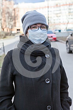 Young woman portrait standing on a street wearing face mask and glasses