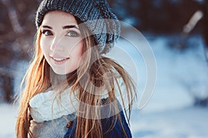 Young woman portrait walking in snowy winter forest, spending christmas vacation outdoor