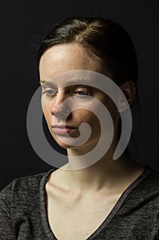 Young woman posing against black background, horizontal