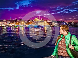 Young woman posing on the backdrop of night Istanbul