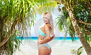 Young woman posing in bikini on beach