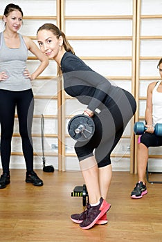 Young woman posing exercise with bar in gym