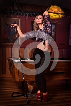 Young woman posing in front of billiard pool table