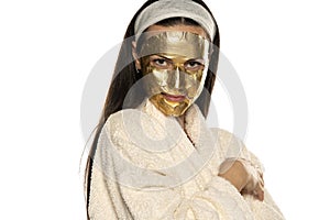 Young woman posing with golden mask on her face