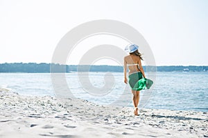 Young and woman posing in a hat on the beach