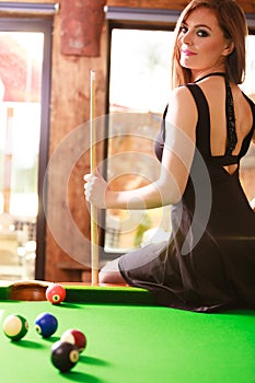 Young woman posing having fun with billiard.