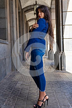 Young woman posing for a portrait holding her shoulder.