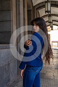 Young woman posing for a portrait holding her shoulder.