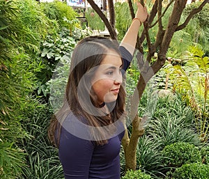 young woman posing recharged in the branches of a tree