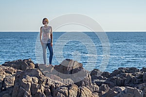 Young woman posing on rocks by the Black sea