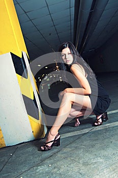 Young woman posing in underground garage