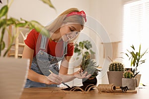 Young woman potting succulent plant. Engaging hobby