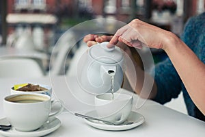 Young woman pouring a cup of tea