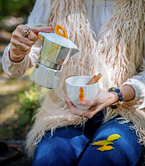 A young woman is pouring herself a cup of coffee