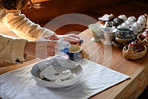 Young woman pouring hot tea in teacup
