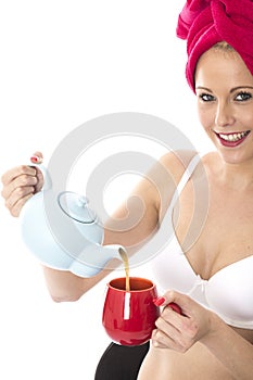 Young Woman Pouring Tea from a Teapot After Shower