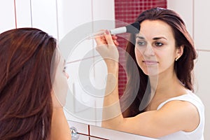 Young woman powdering in bathroom