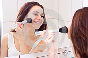 Young woman powdering in bathroom