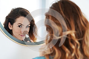 Young woman powdering her nose