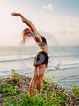 Young woman practice yoga at beach with sunset