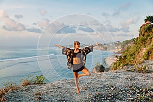 Young woman practice yoga at beach with sunset