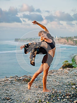 Young woman practice yoga at beach with sunset