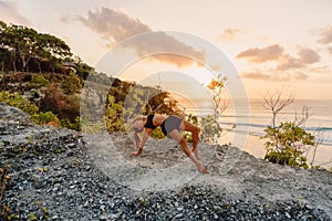 Young woman practice yoga at beach with sunset