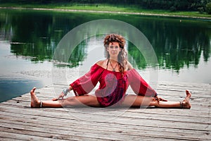 Young woman practice yoga by the lake summer day
