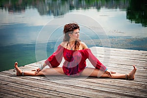 Young woman practice yoga by the lake summer day