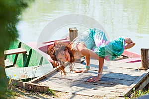 Young woman practice yoga outdoor by the lake balance pose on hands healthy lifestyle concept