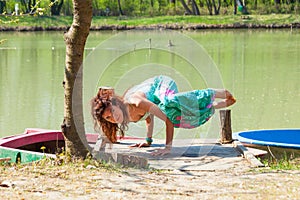 Young woman practice yoga outdoor by the lake balance pose on hands healthy lifestyle concept